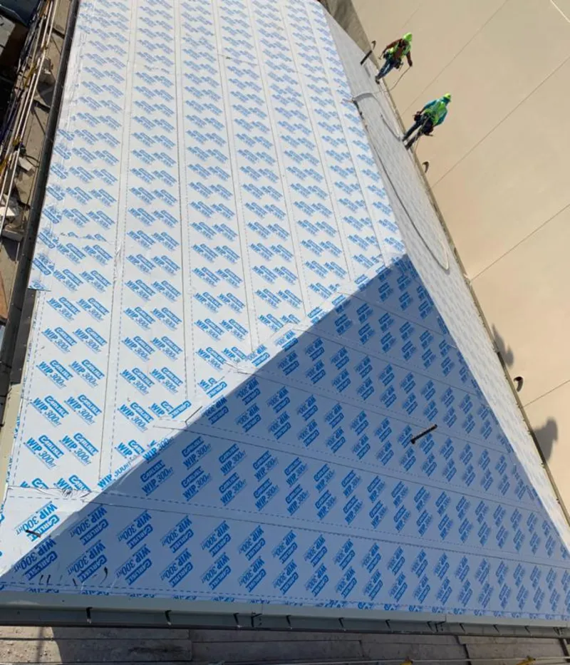 Professional roofers installing underlayment on a metal roof in Warr Acres